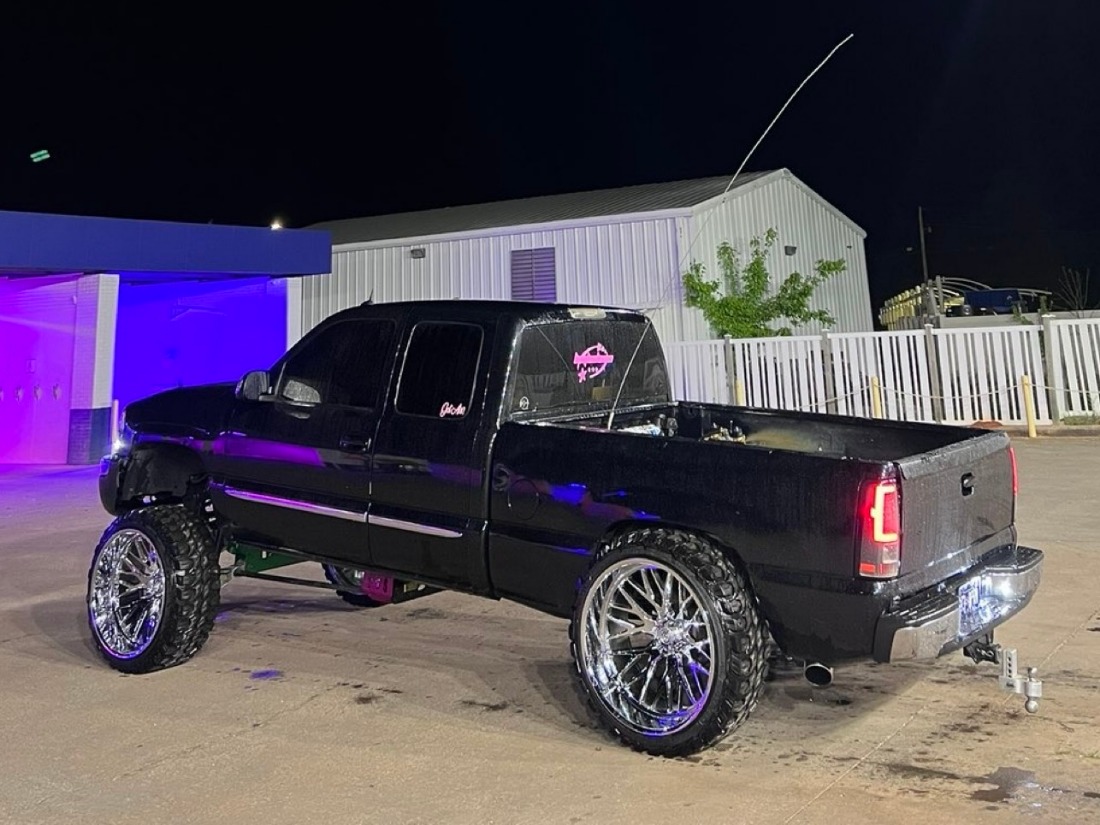 Black lifted truck at night with custom pink decals on the back glass — NeSmith Decals, Huntsville AL